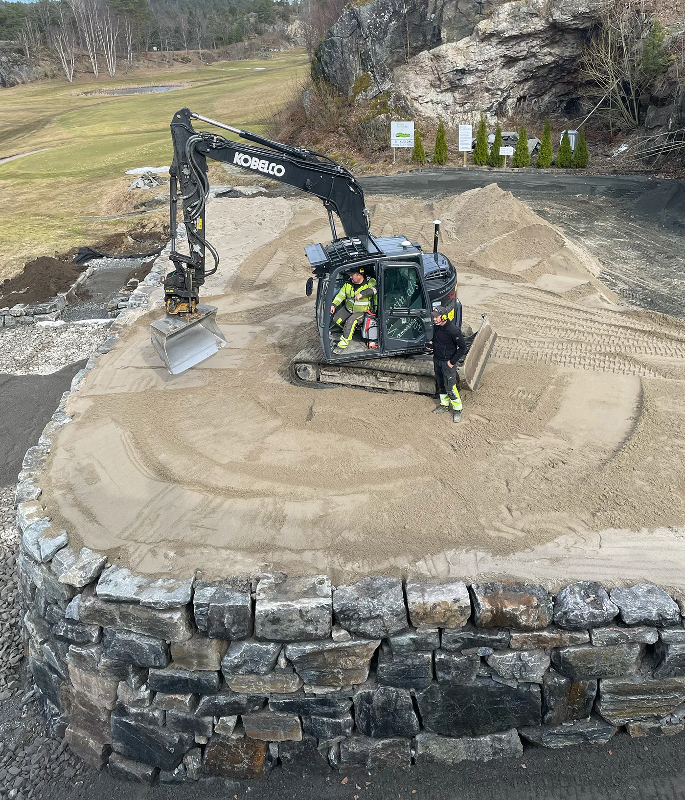 Gravemaskin i full gang med utbedringsarbeid på puttinggreen og drivingrange i Bamble Golfklubb.